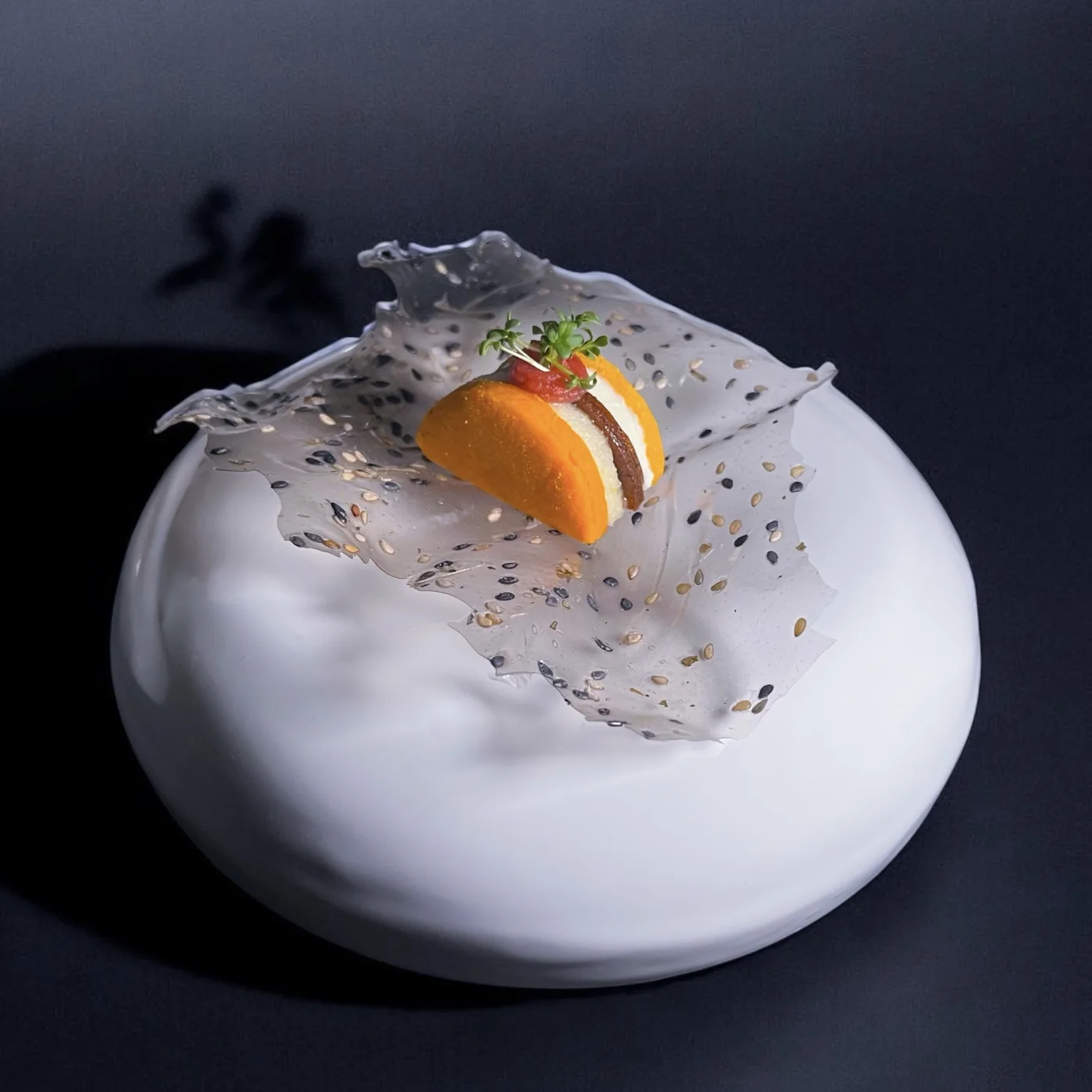 Bocado de autor sobre oblea de sésamo y esfera de porcelana en A Fuego Fuerte