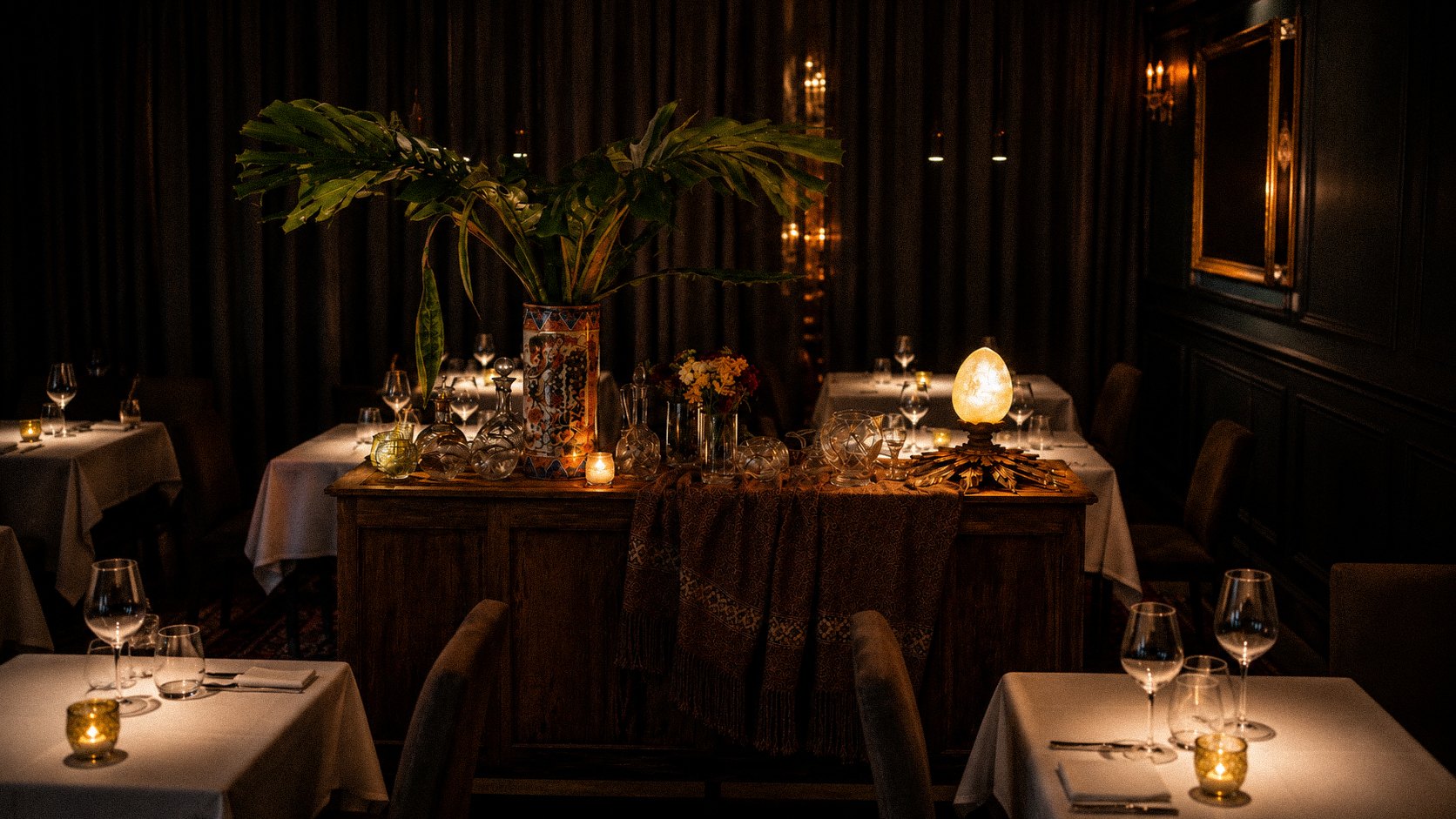 Salón íntimo de A Fuego Fuerte con iluminación dramática y vajilla premium